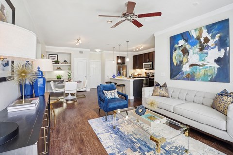 a living room with a white couch and a ceiling fan